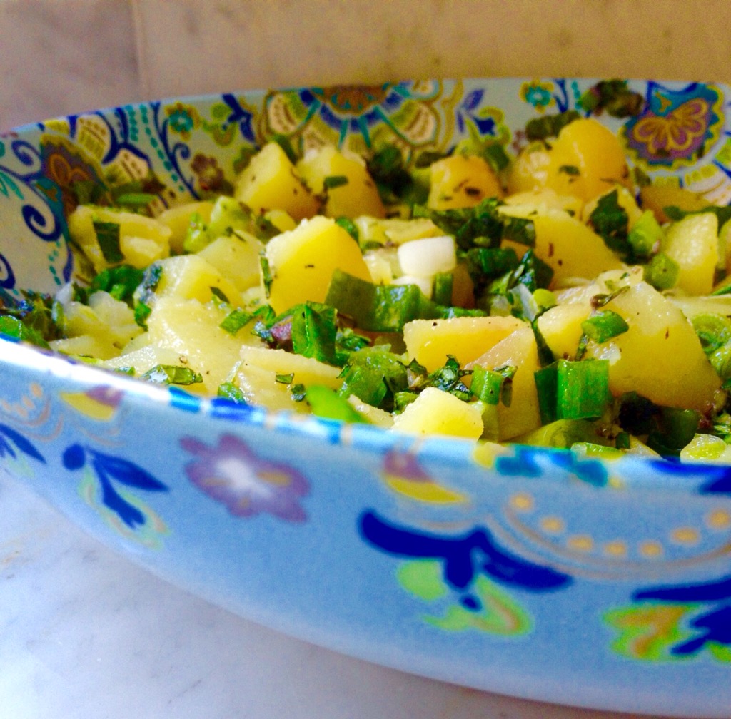 Parsley, green onion, olive oil, and lemon juice atop chopped potatoes
