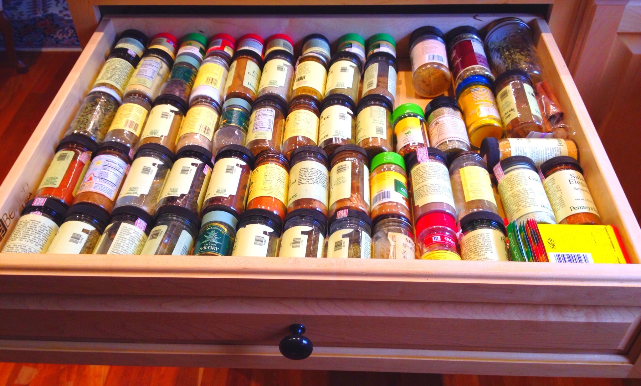 spice jars lay on their sides in a spice drawer