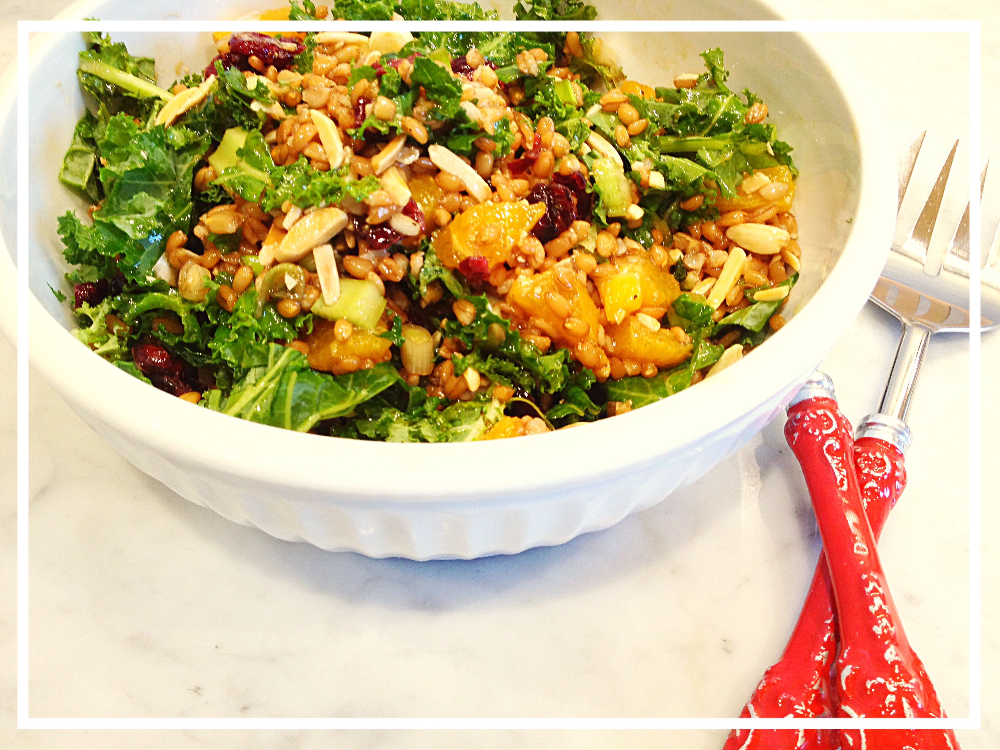 wheat berry salad dotted with almonds, crtanberries, oranges, and kale