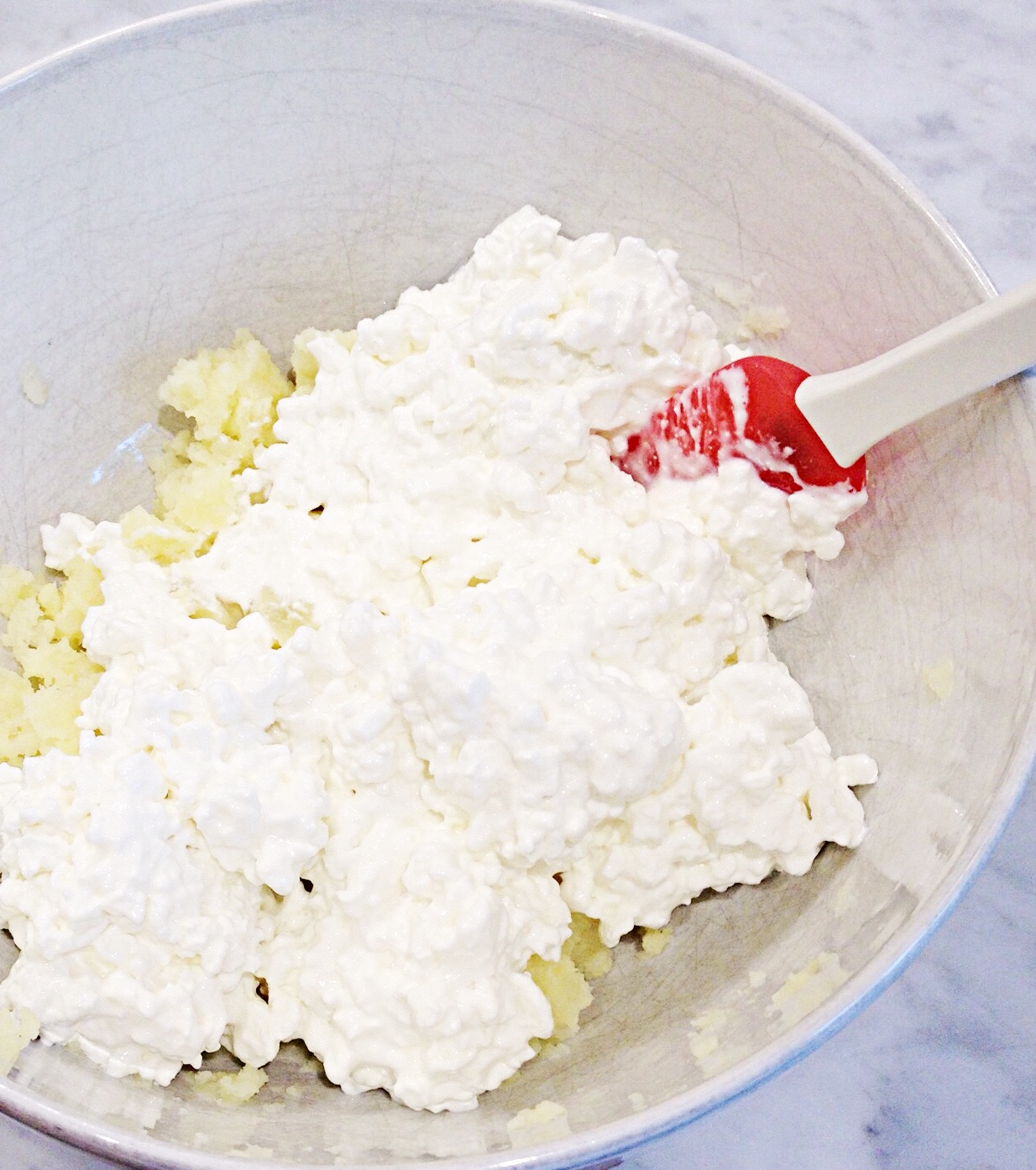Photo of mixing drained cottage cheese with the mashed potato.