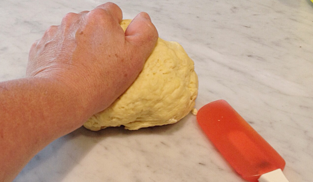 Photo of kneading dough on a marble surface.
