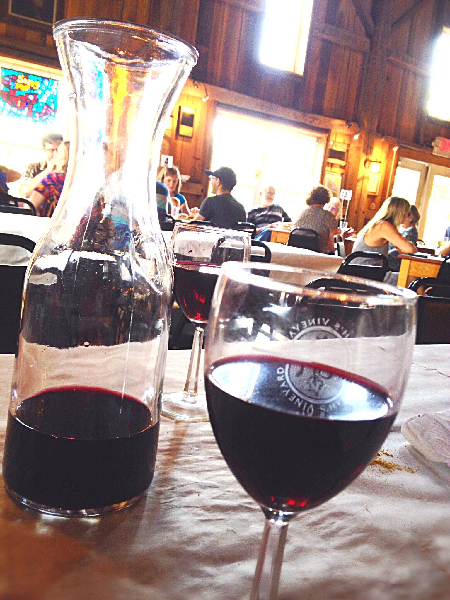 Photo of red wine in liter container and glass