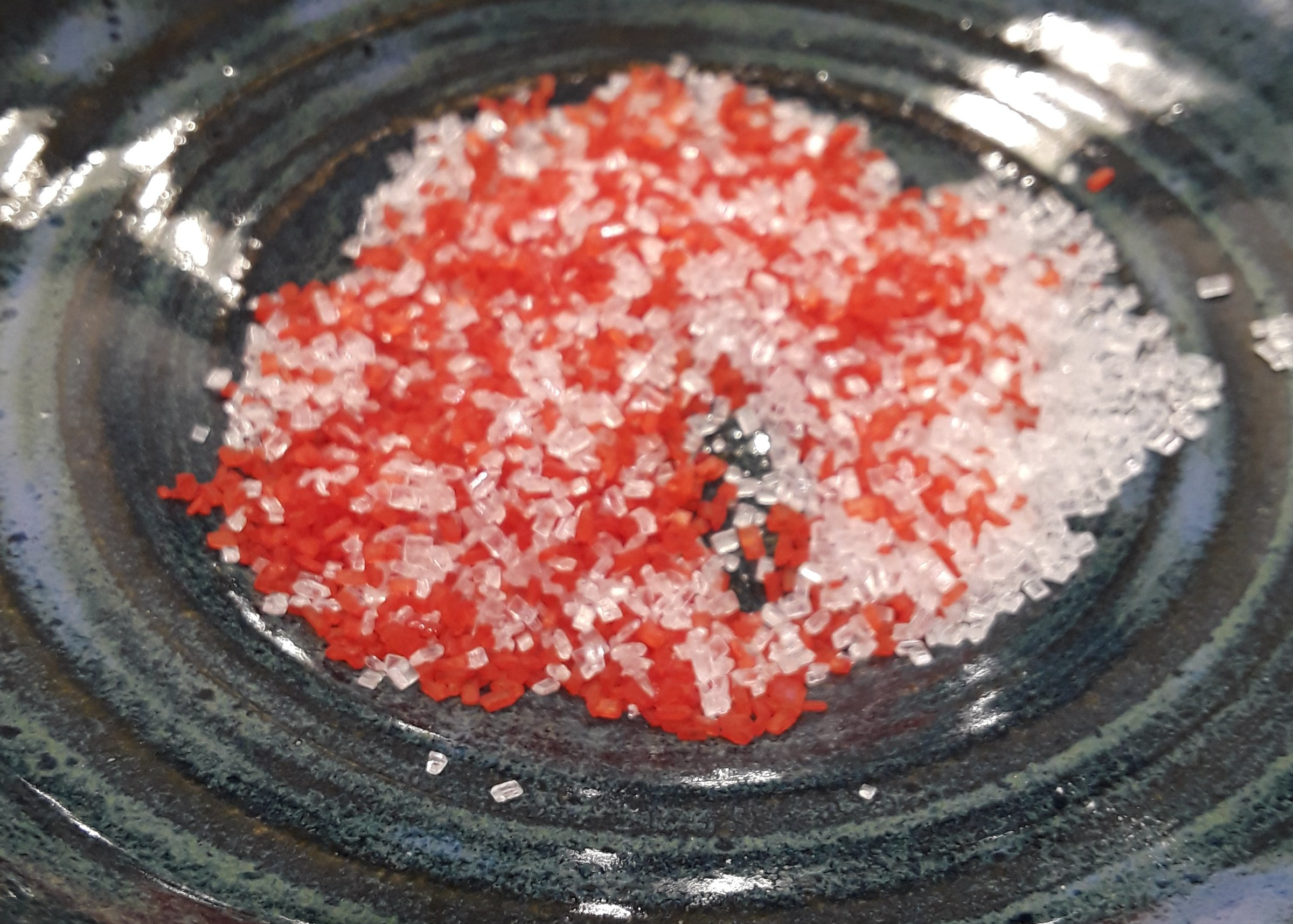 red and white sanding sugar mixed together in bowl.