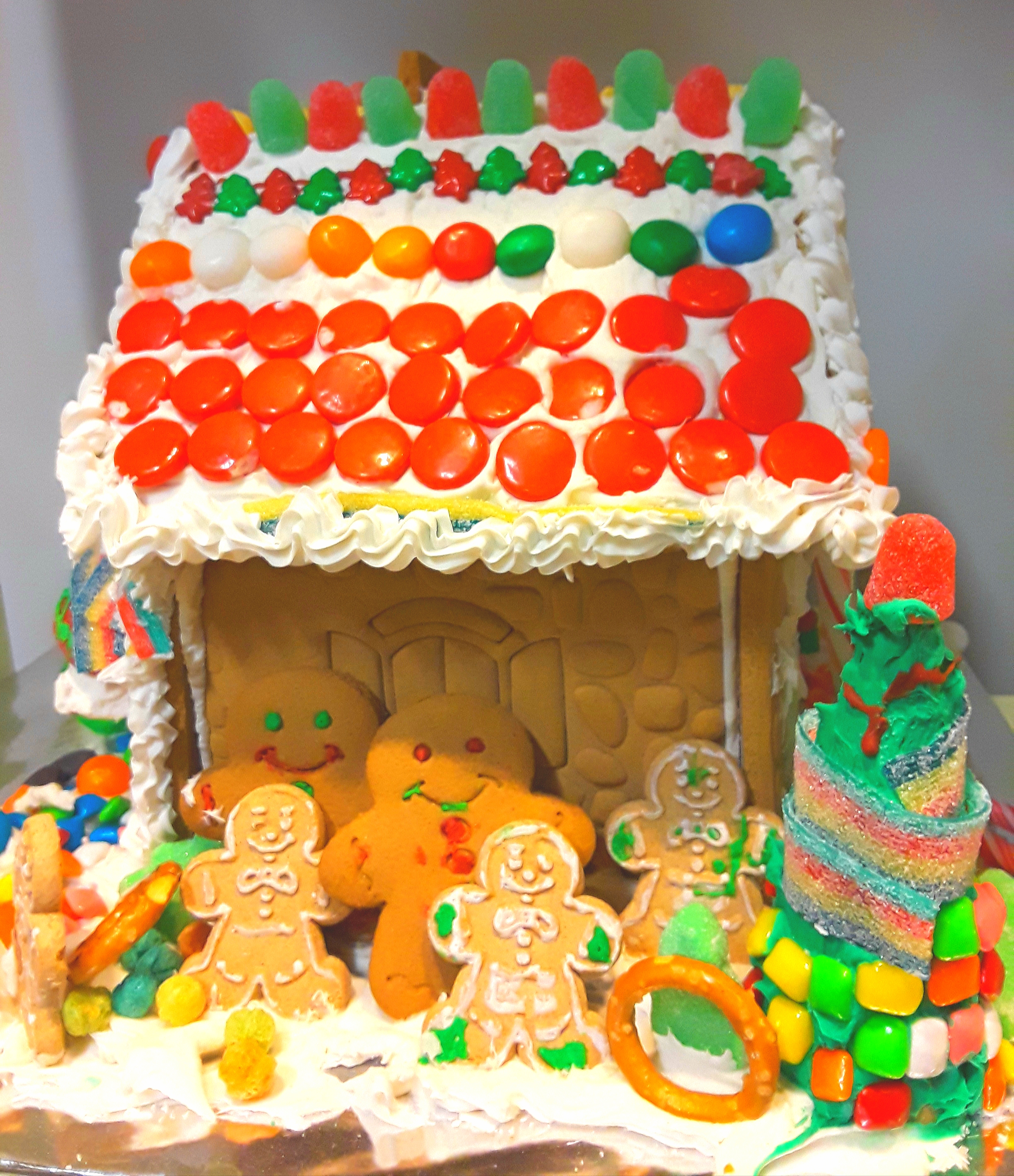 Icing, gumdrops, and candy pieces make a colorful roof on this gingerbread house