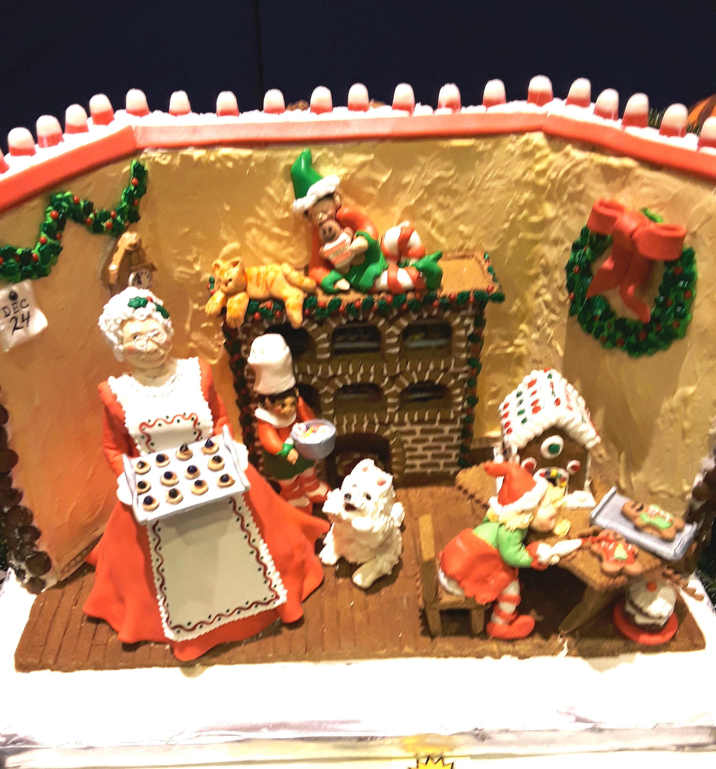 Gingerbread kitchen scene with cook and mini gingerbread house