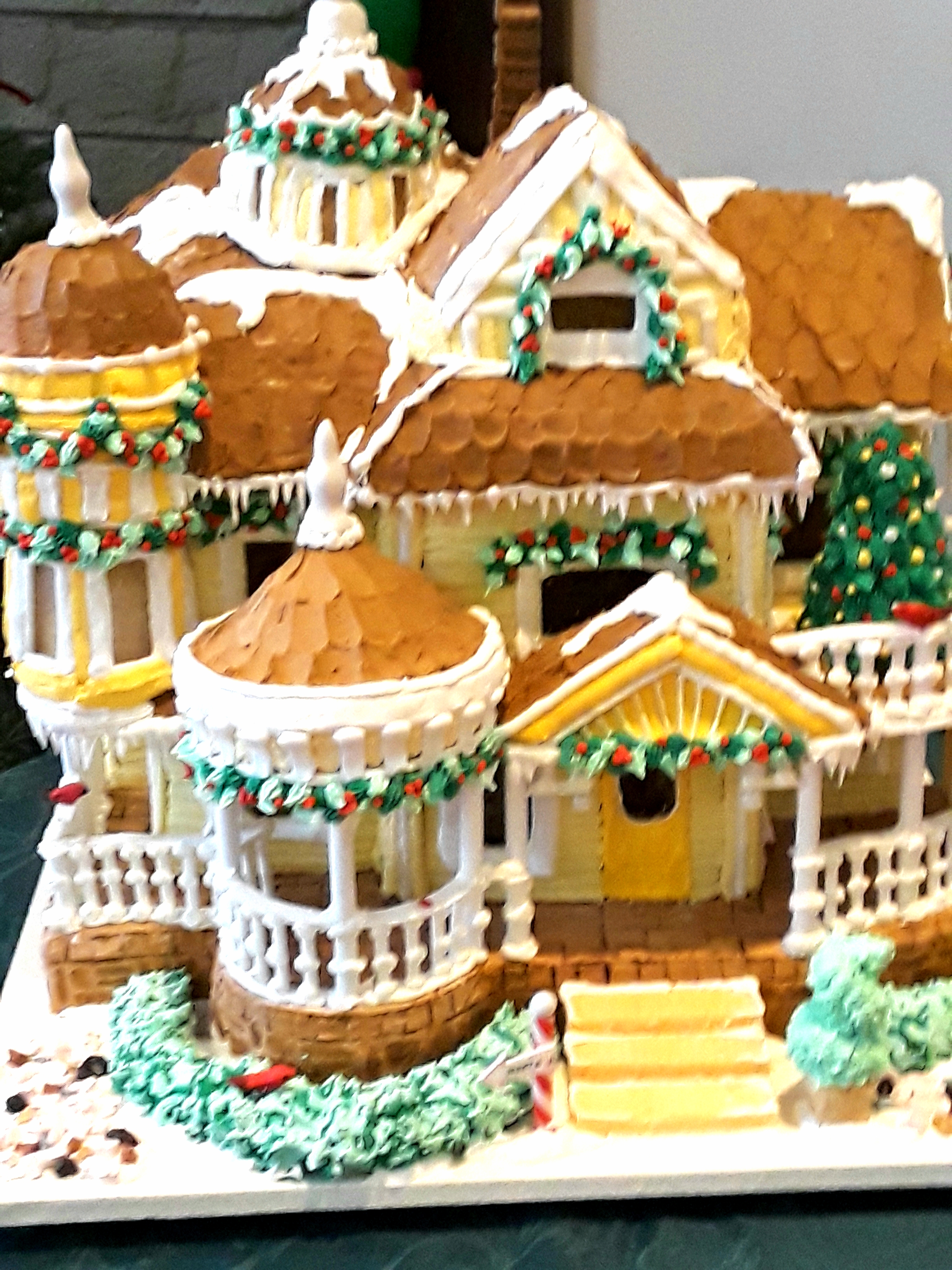 Victorian gingerbread house with yellow frosting and white trim icing