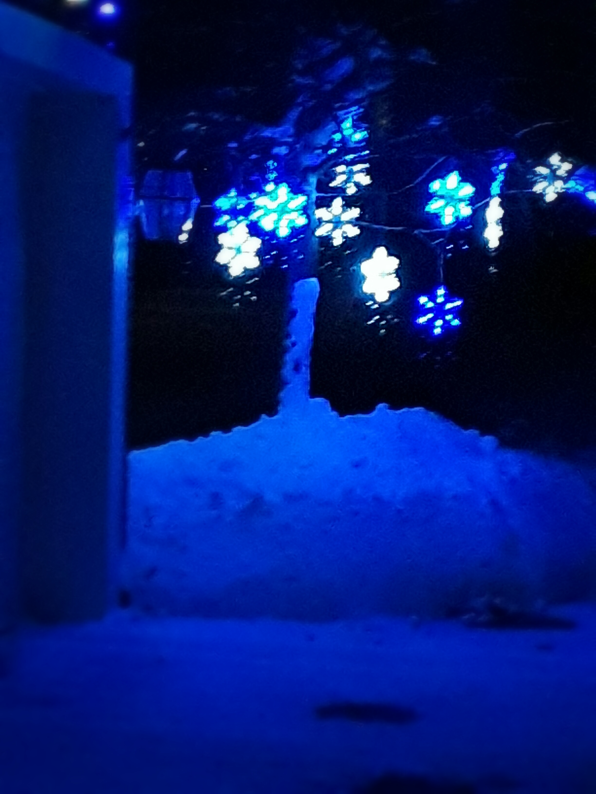 Snowflake holiday lights glow against a snowbank