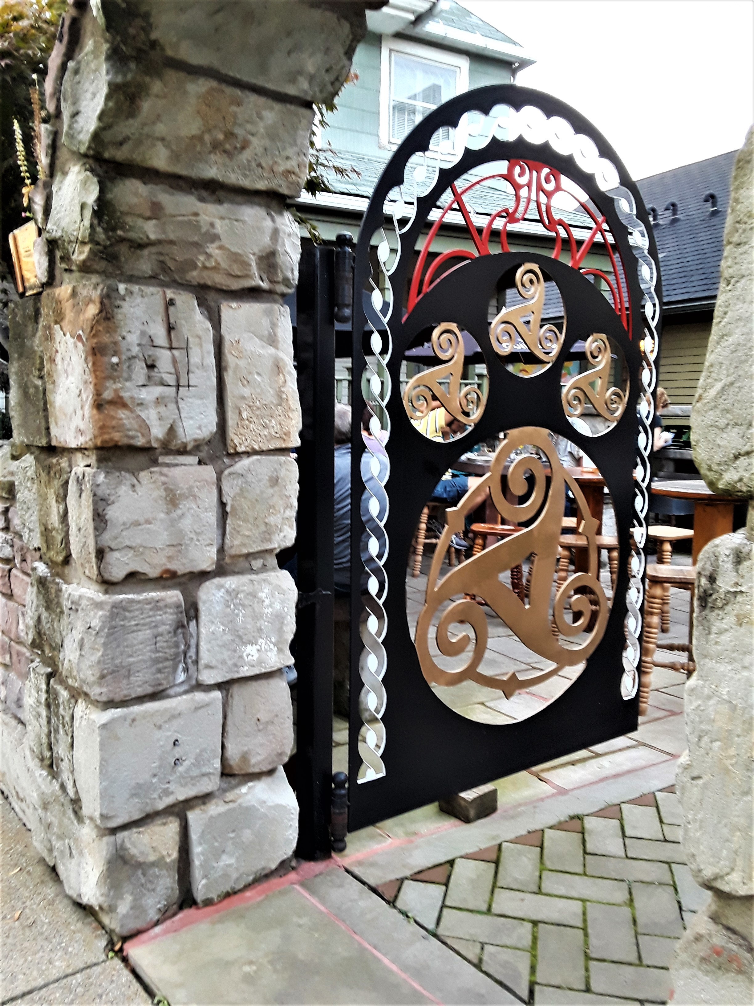 A stylized iron gate welcomes beer lovers to an outdoor patio in the Ohio City neighborhood of Cleveland.