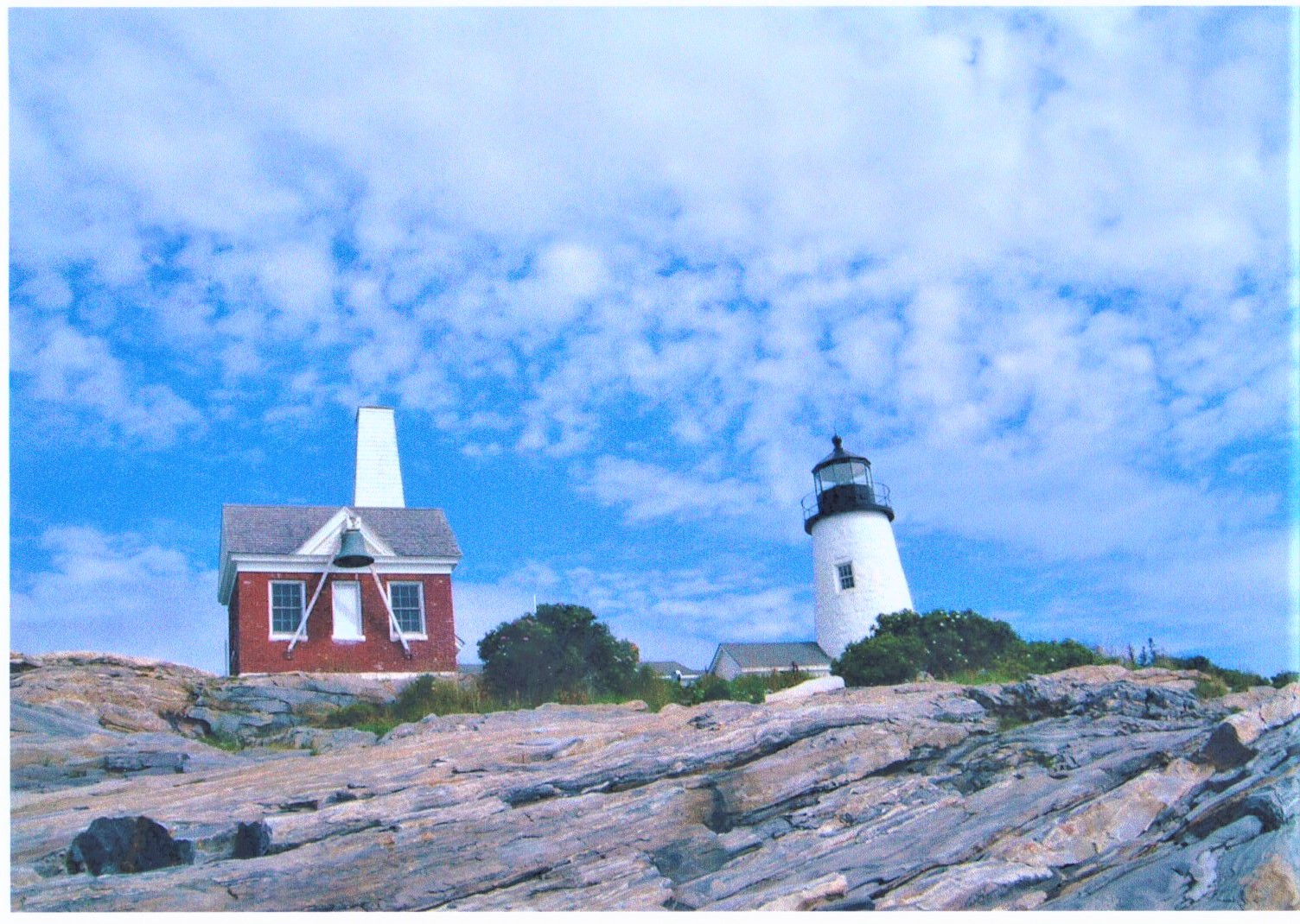 A lighthouse on a small, rocky island off the coast of Maine