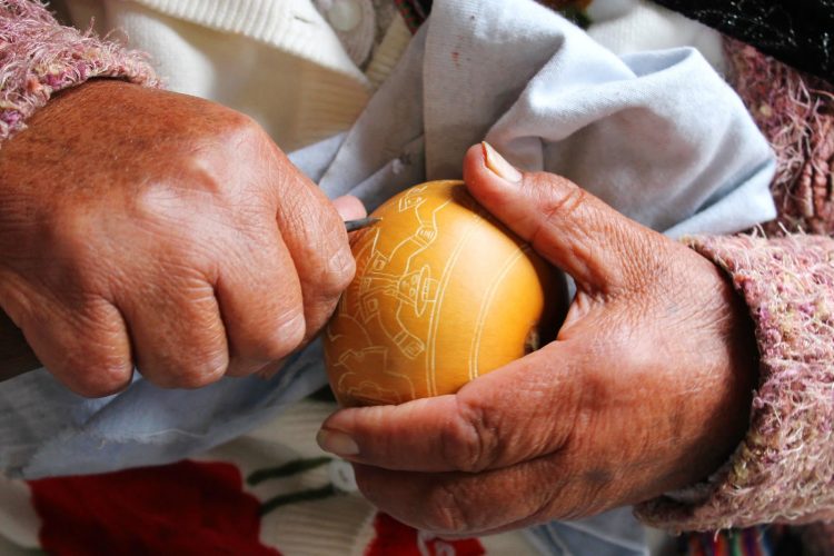 carving a design into the mate using the buril