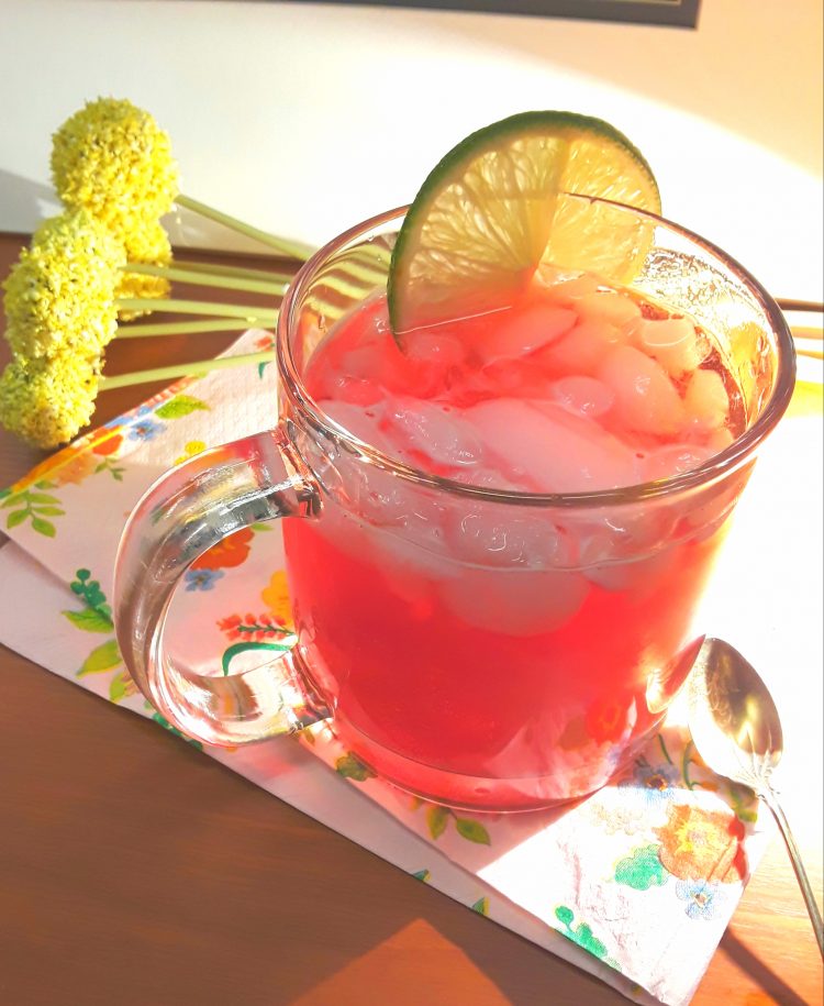 Mug of pomegranate fizz with lime slice