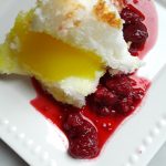 angel food cake is filled with lemon curd and served with raspberry sauce