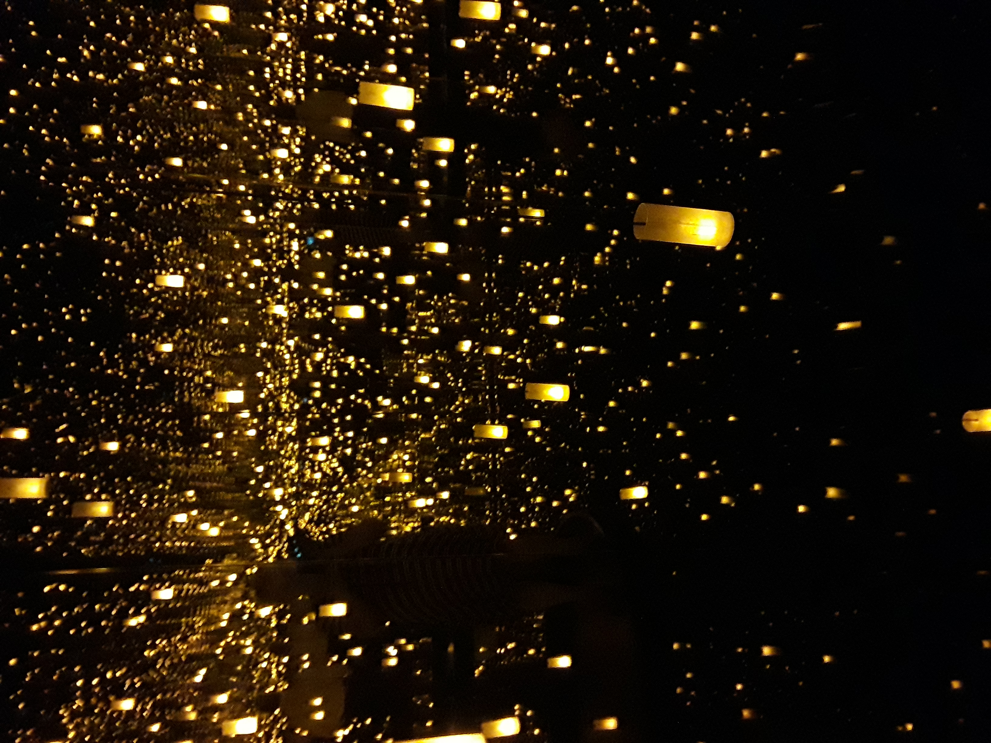 suspended LED lights flicker in the darkened room, reflected in the four walls covered by mirrors