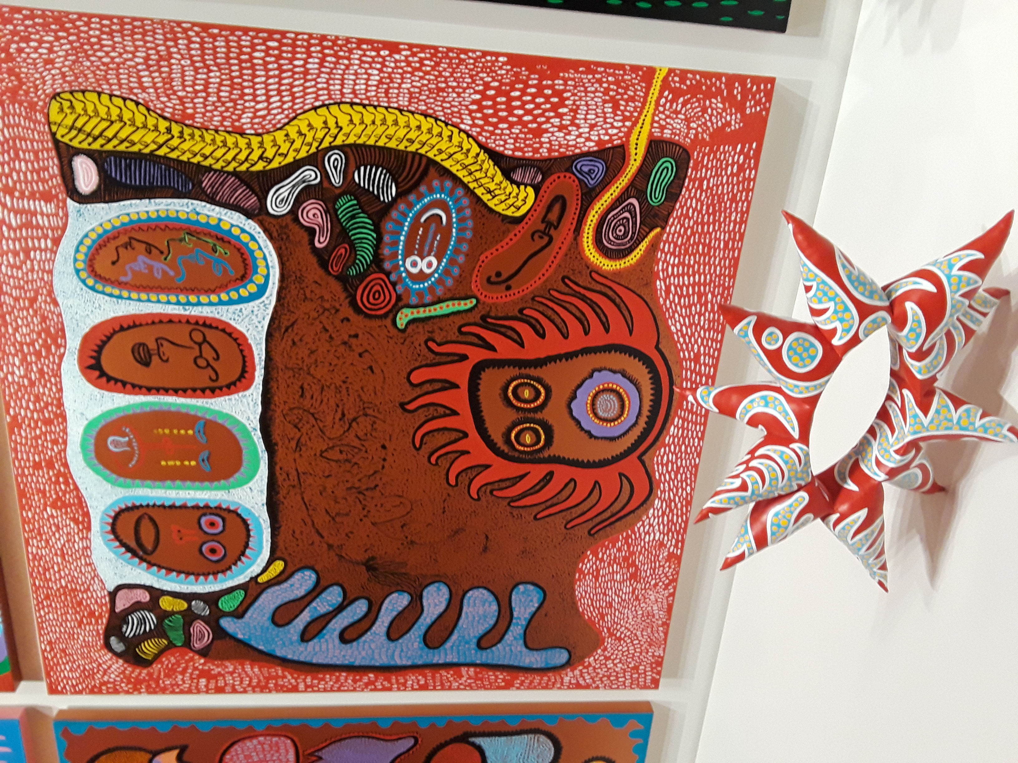A patternedcanvas hangs behind a coordinating paisley sculpture