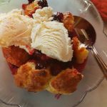 blackberry cobbler is warm and topped with vanilla ice cream