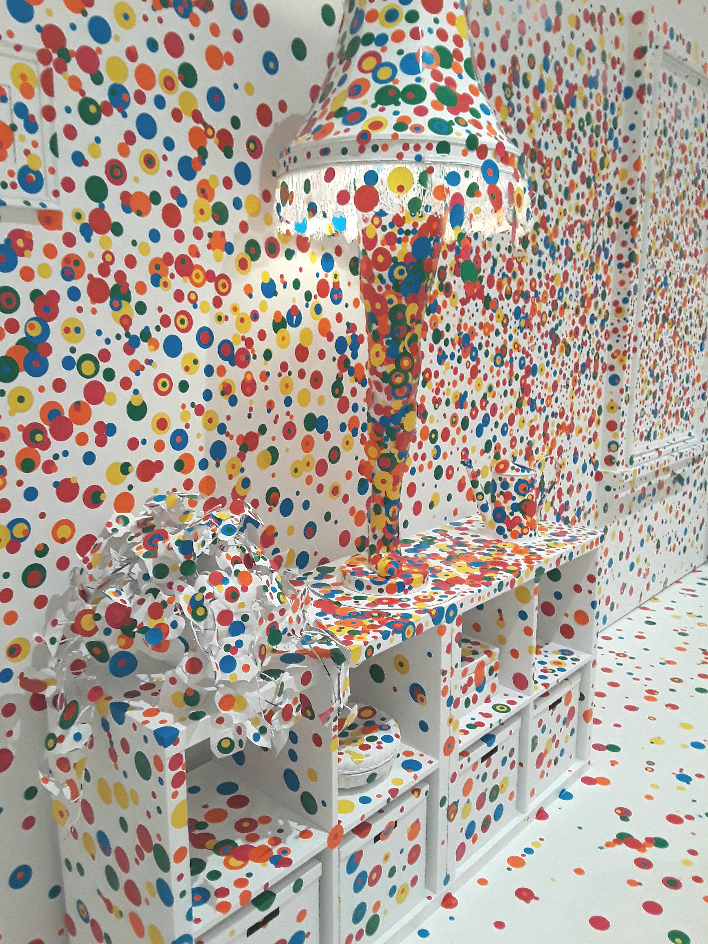 primary-colored dot stickers cover a leg lamp painted white