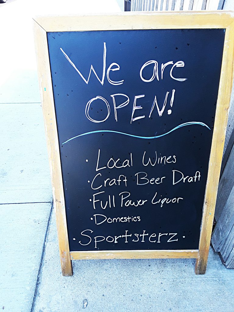 Chalkboard sign advertising local wines, craft beer.