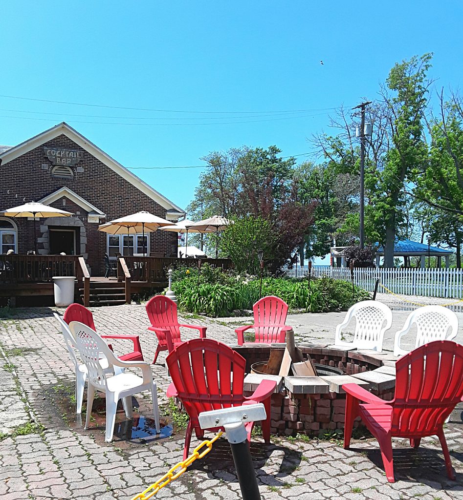 Patio seating outside of the ale house includes a fire pit.