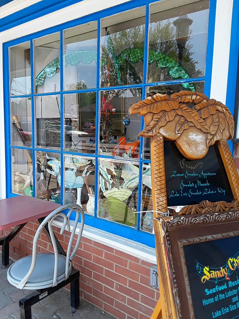 Window of a gift shop filled with beach items.