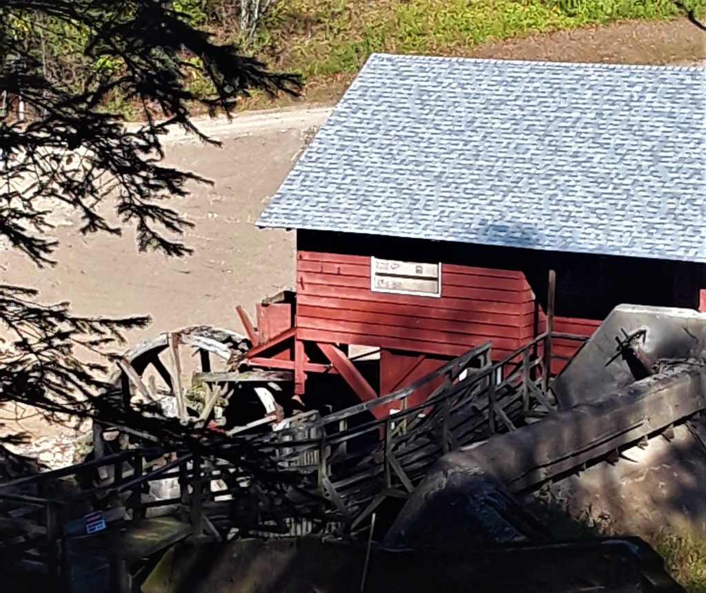 red sided mill building with wooden wheel