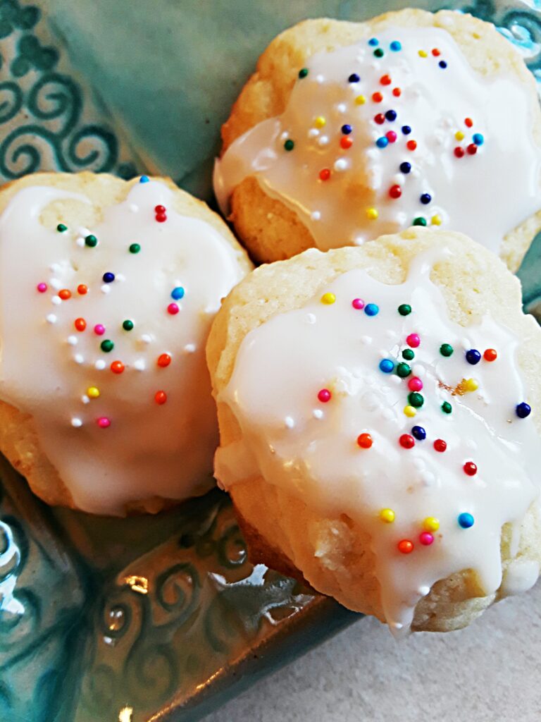 Ricotta cookies are glazed and sprinkled with nonpareils