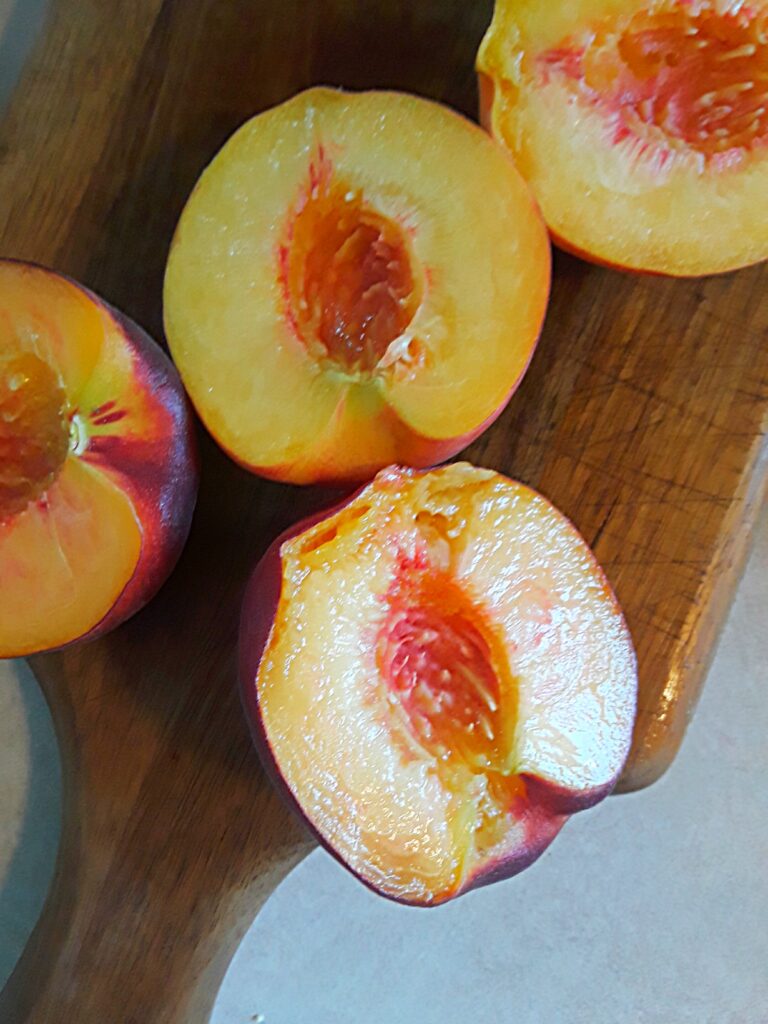 Fresh peaches sliced in halves, stones removed.