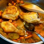 Caramelizing the chicken pieces with the chopped onions and carrots