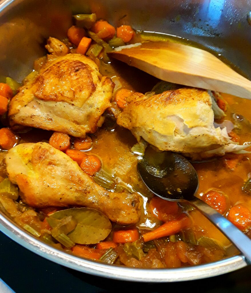 Caramelizing the chicken pieces with the chopped onions and carrots