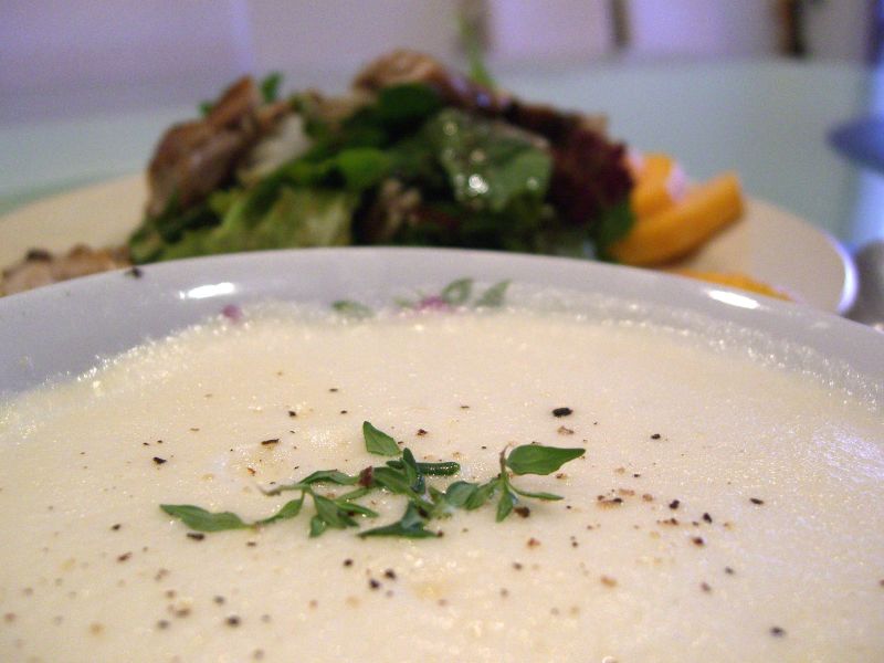 Avgolemono soup is garnished with fresh chopped herbs