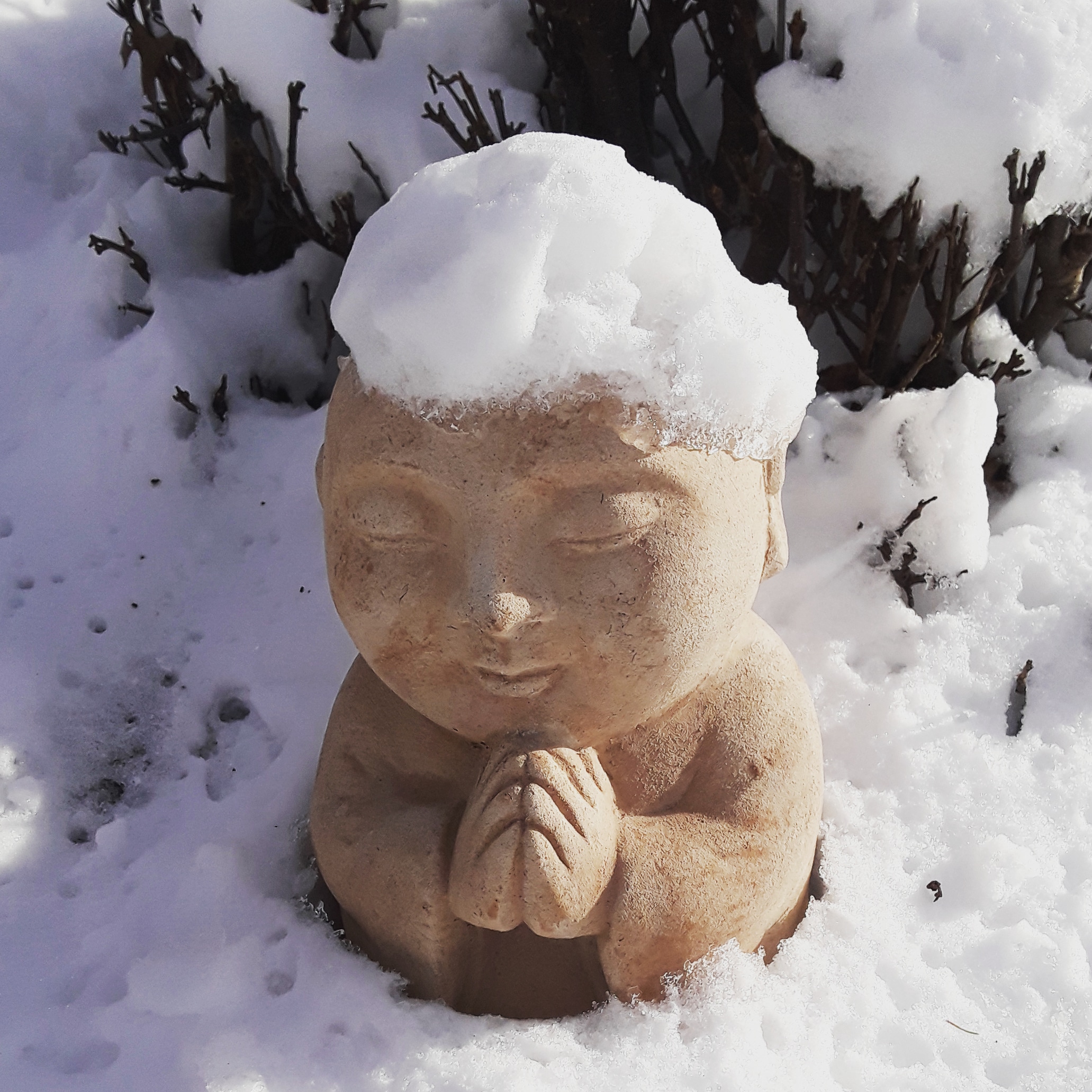 Buddha statue in garden covered with snow