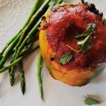 Middle Eastern Style Stuffed Peppers are capped wih tomato puree and a sprinkling of chopped mint leaves.