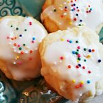 Ricotta cookies are glazed and sprinkled with nonpareils